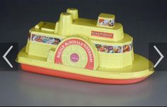 a yellow toy boat sitting on top of a gray table next to a white arrow