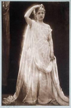 an old photo of a woman in a white dress with a veil on her head