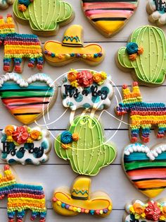 colorful decorated cookies are arranged on a white table with the words fiesta written in it