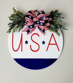 a red, white and blue wreath with the word usa on it hanging on a wall