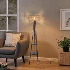 a living room with a chair, lamp and pictures hanging on the wall behind it