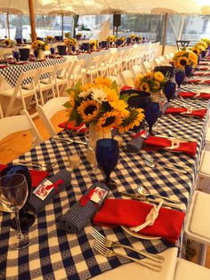 the table is set with blue and white checkered cloth, red napkins, and sunflowers