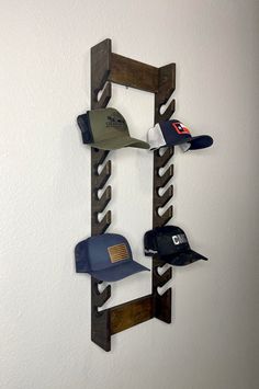 several hats are hanging on a wooden rack