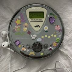 an electronic device with many stickers on it's face and earbuds