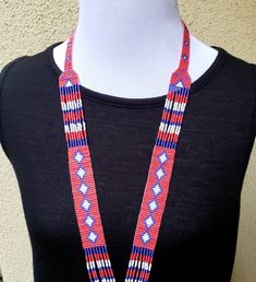 Colorful long shiny Native American seed bead necklace with fun fringe in a striking pattern. This necklace says summer, beach, resort. Necklace measures 16 inches, pendant measures 4 1/2 inches from top to the bottom of the fringe. No clasp, just slip over your head. Striking with a swingy beach dress or a jean jacket. Shop more necklaces here: https://www.etsy.com/shop/BoutiqueByMaryam?section_id=21694658 Be sure to visit the rest of my shop here: https://www.etsy.com/shop/boutiquebymaryam Beaded Lariat Necklace For Festival, Southwestern Lariat Jewelry For Festivals, Southwestern Necklaces With Dangling Beads And Adjustable Fit, Southwestern Necklace With Dangling Beads And Adjustable Fit, Artisan Necklace With Beaded Fringe And Adjustable Fit, Southwestern Beaded Necklace With Dangling Beads For Festivals, Bohemian Lariat Beaded Necklace With Large Beads, Bohemian Lariat Necklace With Dangling Beads, Southwestern Style Red Necklace For Festivals