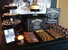 a table topped with lots of desserts next to a chalkboard sign that says jack daniels