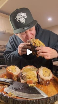 a man eating some food on top of a wooden cutting board