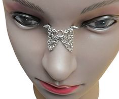 a mannequin's head with chains attached to the face and nose piece