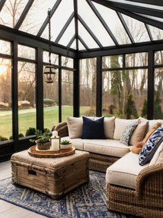 a living room filled with lots of furniture next to a large glass wall covered in windows