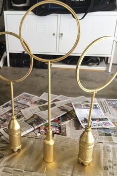 three golden metal candles on top of newspaper