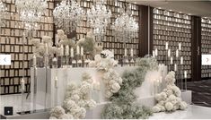 a room filled with lots of white flowers and candles