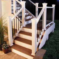 a set of stairs leading up to a porch with potted plants on the side