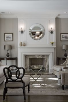 a living room filled with furniture and a fire place under a mirror on the wall