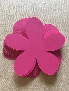 pink paper flowers are stacked on top of each other in the shape of a flower