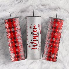 two red and white tumblers with the word christmas written on them, sitting next to each other