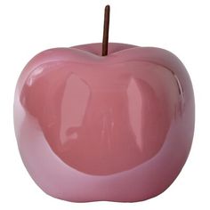 a pink apple shaped object with a wooden stick sticking out of it's center