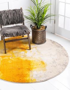 a chair sitting on top of a rug next to a potted plant in a room