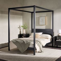 a bedroom with a four post bed and two nightstands