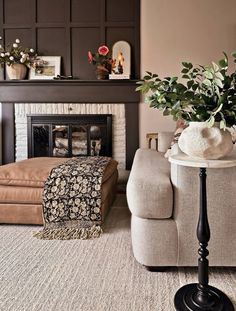 a living room filled with furniture and a fire place in front of a wall mounted fireplace