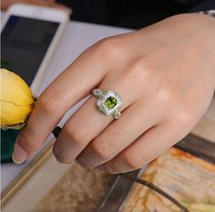 *Condition: Brand new *Center Stone: Natura Tsavorite Green Garnet, Cushion Shape, approx 1.15ct *Side Stone: Natural white diamond, round cut (VS1 clarity and F color) Natural Tsavorite round cut *Ring Weight: 5.62g (depend on the ring size) *Metal Purity: Optional Each piece is made-to-order with care and special attention to detail. all items are made with conflict-free diamonds and gems. Size: made to order The item will be gift wrapped and shipped. ------------------------------------------ Green Moissanite Diamond Ring, Round Cut, Green Moissanite Diamond Ring With Round Cut, Luxury Green Round Cut Halo Ring, Luxury Green Halo Ring With Brilliant Cut, Luxury Green Halo Ring With Center Stone, Green Diamond Halo Ring In Round Cut, Luxury Green Diamond Ring With Halo Design, Wedding Jewelry With Brilliant Cut Peridot, Green Diamond Halo Ring With Round Cut