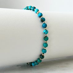 Step into a world of understated elegance with our Genuine Turquoise & Solid Gold Minimalist Bracelet. This exquisite piece features guaranteed 100% natural high-quality 4mm round natural turquoise beads, enhanced with 2mm solid yellow gold beads. Its minimalist design complements any outfit, adding a sophisticated touch to your daily wear. Bracelet Pack, Awareness Bracelet, Natural High, Minimalist Bracelet, Genuine Turquoise, Understated Elegance, Natural Turquoise, Glass Necklace, Turquoise Beads