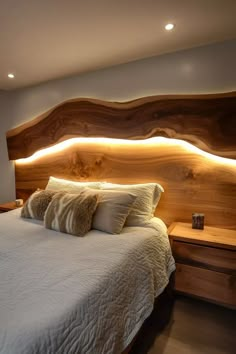 a large bed sitting in a bedroom next to a wooden headboard and night stand