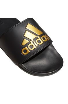 Versatile and comfortable, this bandage-style slide cushioned with a contoured footbed is perfect for laid-back days. Open toe Slip-on style Synthetic upper/textile lining/synthetic sole Imported Adidas Slides For Swimming, Adidas Slides For Swimming In Summer, Adidas Slides For Summer Swimming, Adidas Open Toe Sports Flip Flops, Black Open Toe Flip Flops For Swimming, Adjustable Black Slip-on Slides, Adjustable Black Non-slip Slides, Black Adjustable Non-slip Slides, Adidas Black Slides For Summer