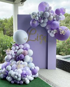 purple and white balloons are on display in front of a sign that says lisg