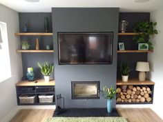 a living room filled with furniture and a flat screen tv mounted on the wall above a fire place