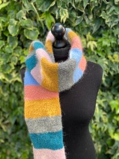 Hand knitted brushed alpaca and wool tube scarf in grey, blues, pinks and mustard. This tube scarf is double sided showing only the right side of the knit.  Ideal for colder months as this scarf is very thick and will keep you very warm.  All my scarves are hand knitted by myself in Wales, UK, using sustainable natural fibers.  Wrapped and supplied with non plastic materials. Measurements: Scarf is shown on dummy size 8 (UK size). Length: 160 cm Width: 12 cm Weight: 195 g Contents:  4% Polyamide Thick Scarf, Wales Uk, Tube Scarf, Striped Scarves, Double Face, Winter Scarf, Natural Fibers, Scarf Wrap, Alpaca