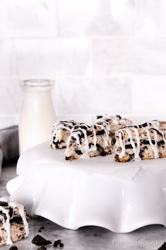 chocolate chip cookies and marshmallows on a white platter next to a bottle of milk