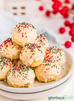 a white plate topped with cookies covered in frosting and sprinkles on top of a table