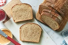 three slices of bread sitting on top of a cutting board next to butter and jelly