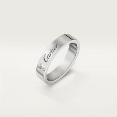 a white gold ring with the word carrier engraved on it's side and a single diamond