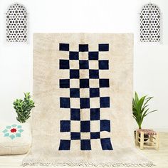 a blue and white rug on top of a wooden table next to a potted plant