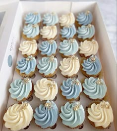 a box filled with blue and white cupcakes