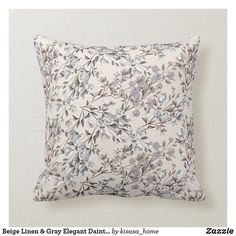 a white pillow with blue and grey flowers on it