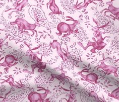 a pink and white fabric with rabbits on it