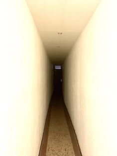 an empty hallway with a clock on the wall