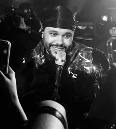 a black and white photo of a man singing into a microphone