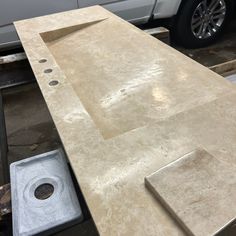 a white truck parked next to a counter top in a garage with tools on it