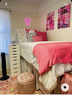 a bed room with a neatly made bed and lots of pink decorations on the wall