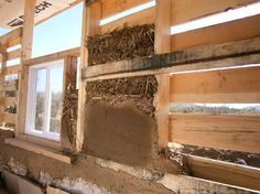 the inside of a house being built with wood framing and straw bales on the windowsill