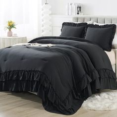 a black comforter set with ruffled edges on a bed