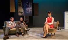 three people sitting in chairs on stage