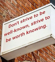 a sign on the side of a brick building that says don't strive to be well - known, strive to be worth kw