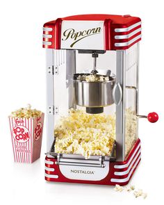 an old fashioned popcorn machine with two buckets of popcorn next to it on a white background