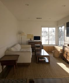 a living room filled with furniture and a flat screen tv on top of a wooden dresser