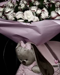 a stuffed animal sitting next to a bouquet of flowers