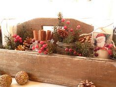 a wooden box filled with pine cones and candles